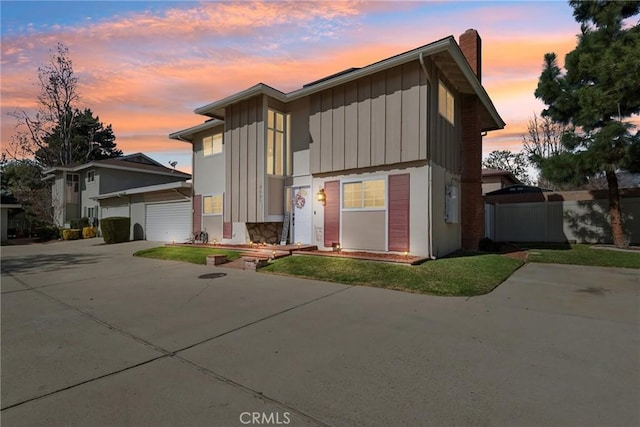 view of front facade with driveway, board and batten siding, and an outdoor structure