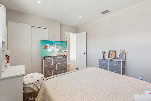 bedroom with a closet, visible vents, and recessed lighting