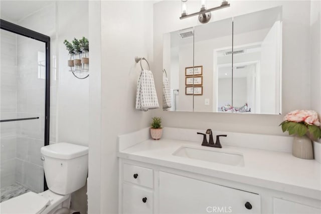 bathroom with visible vents, vanity, a shower stall, and toilet