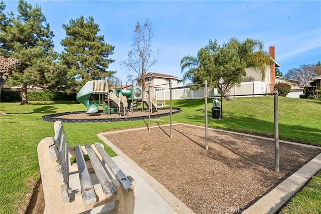 community play area featuring a lawn and fence