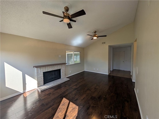 unfurnished living room featuring a fireplace, visible vents, vaulted ceiling, a textured ceiling, and wood finished floors