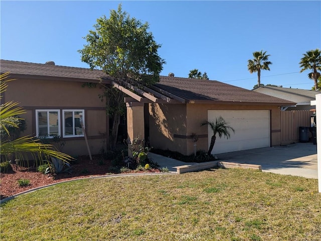 view of front of home featuring a garage, a front yard, concrete driveway, and stucco siding