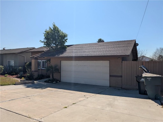 view of front facade with a garage, concrete driveway, fence, and stucco siding