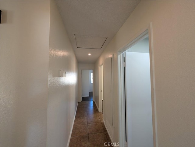 hallway featuring tile patterned flooring and baseboards