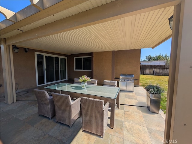 view of patio / terrace with outdoor dining space, a grill, and fence