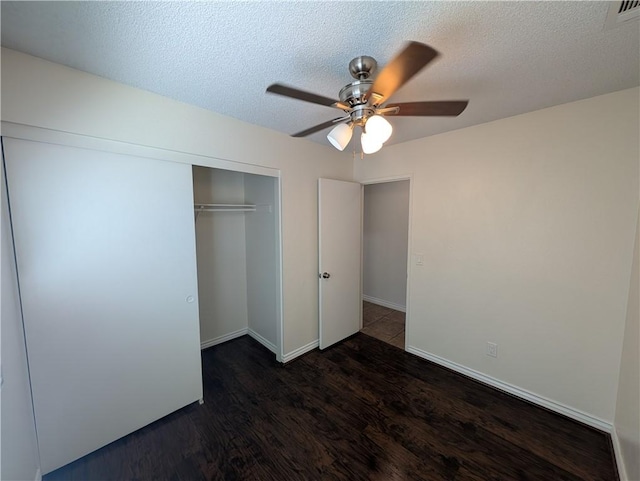 unfurnished bedroom featuring a closet, visible vents, a textured ceiling, wood finished floors, and baseboards