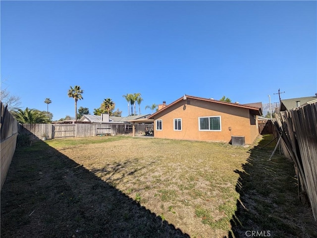 view of yard with central AC unit and a fenced backyard