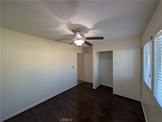 unfurnished bedroom with baseboards, a ceiling fan, dark wood-style flooring, a textured ceiling, and a closet