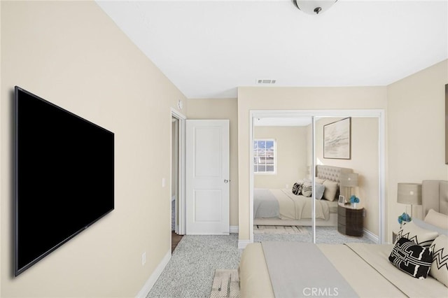 bedroom with baseboards, a closet, visible vents, and carpet flooring