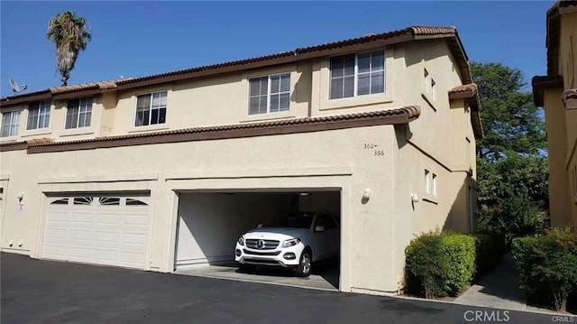 view of front of property featuring a garage, driveway, and stucco siding