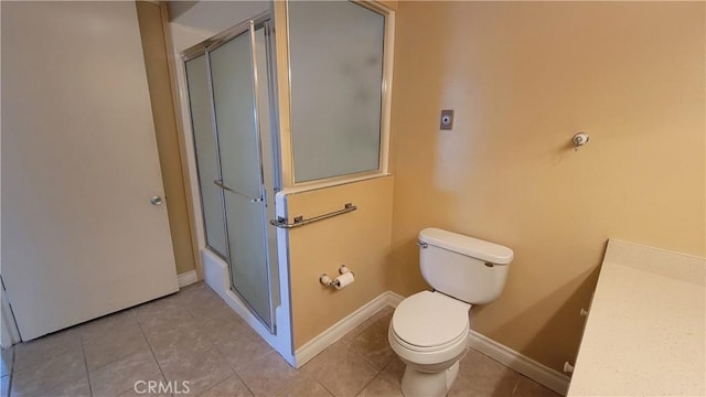 bathroom with tile patterned flooring, baseboards, a shower with door, and toilet