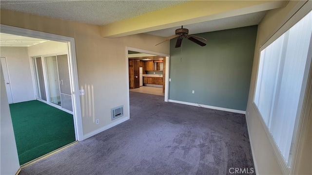 carpeted spare room with a textured ceiling, ceiling fan, visible vents, and baseboards