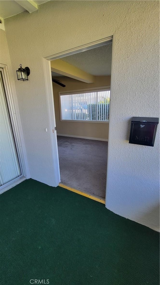 carpeted spare room featuring a textured ceiling and a textured wall