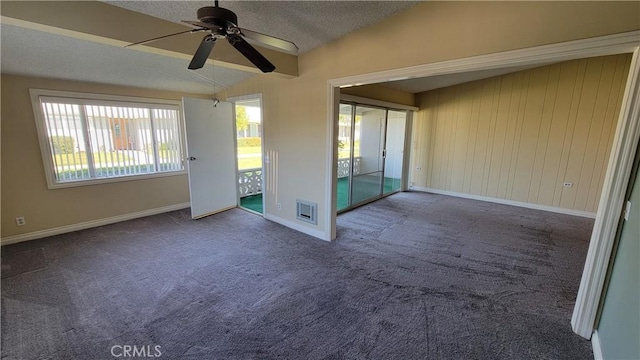 spare room with baseboards, visible vents, lofted ceiling, a textured ceiling, and carpet floors