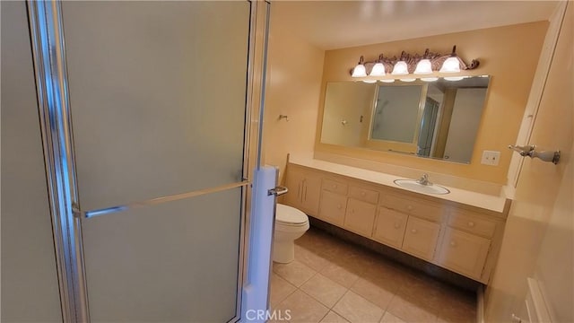 bathroom with toilet, tile patterned flooring, a shower stall, and vanity