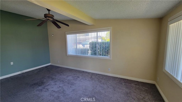 carpeted empty room featuring vaulted ceiling with beams, ceiling fan, baseboards, and a textured ceiling