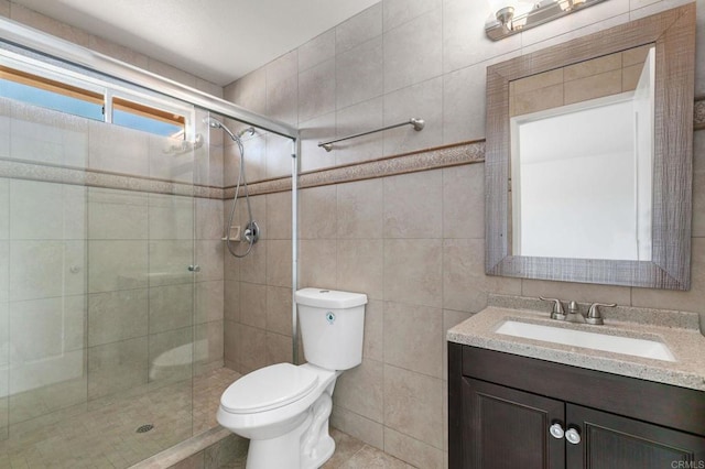 full bath featuring tile walls, a shower stall, toilet, and vanity