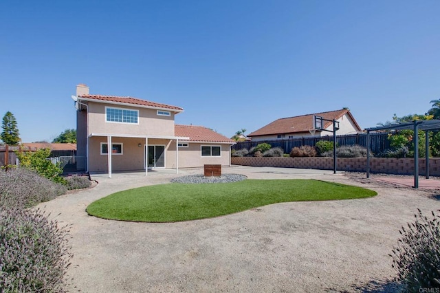 back of house with a patio, fence private yard, a tile roof, stucco siding, and a chimney