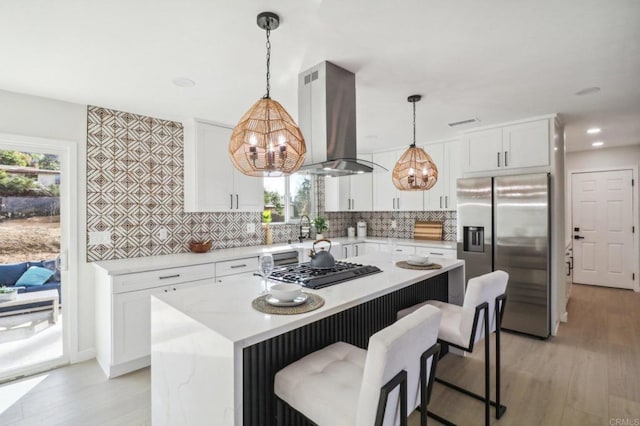 kitchen featuring tasteful backsplash, a center island, island range hood, and stainless steel fridge with ice dispenser