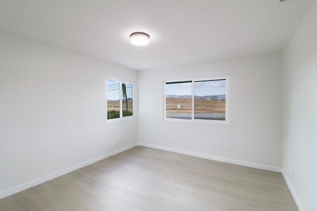 spare room with light wood finished floors and baseboards