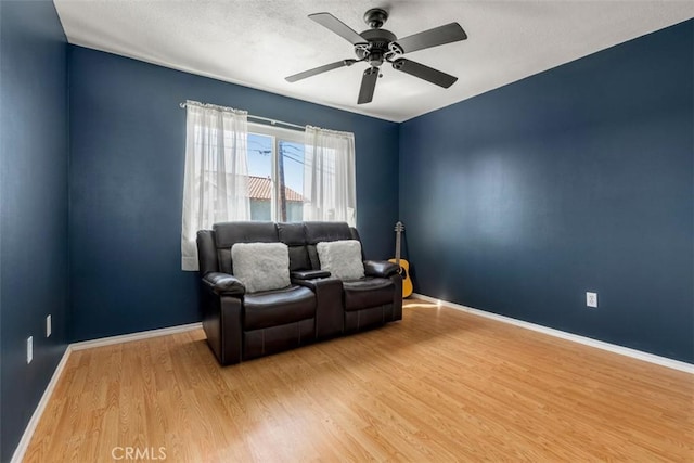 sitting room featuring ceiling fan, baseboards, and wood finished floors