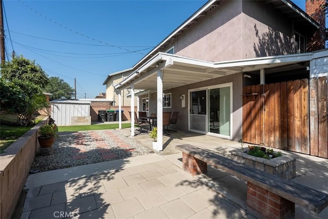 back of house with a patio, fence, and stucco siding