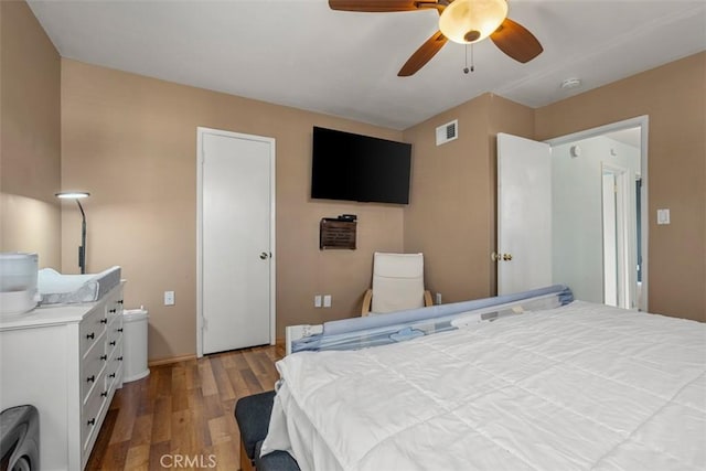 bedroom with a ceiling fan, visible vents, and wood finished floors