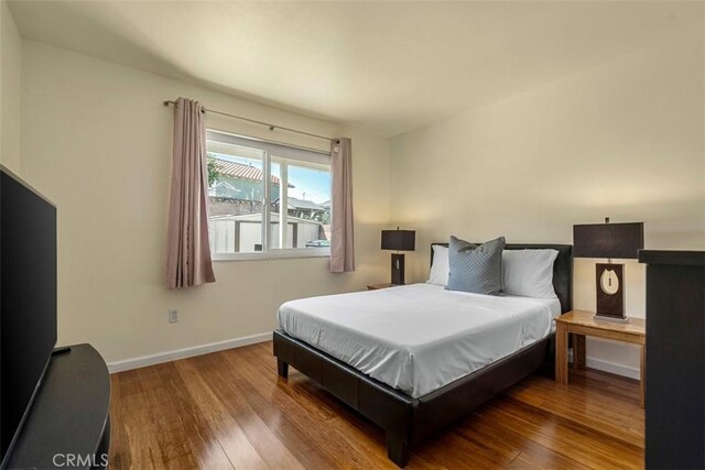 bedroom featuring baseboards and wood finished floors