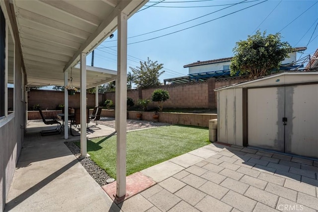 view of patio featuring a storage unit, an outdoor structure, and a fenced backyard