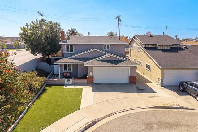 traditional-style home featuring concrete driveway, an attached garage, fence, a front lawn, and stucco siding