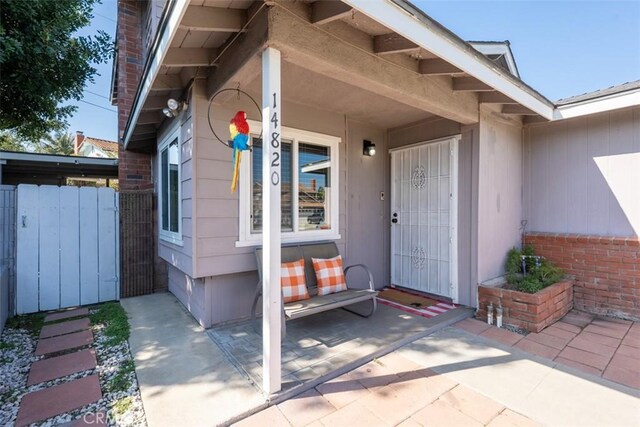 property entrance with brick siding and fence