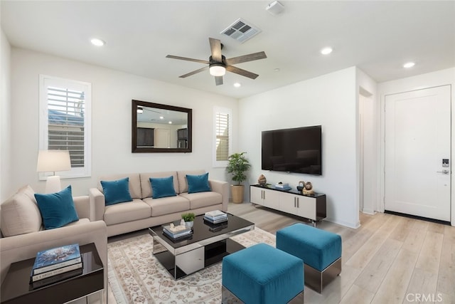 living room with light wood finished floors, ceiling fan, visible vents, and recessed lighting