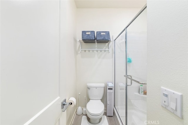 bathroom with a shower stall and toilet