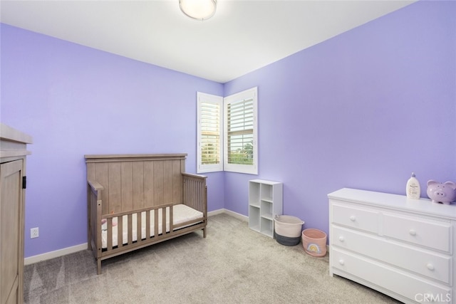 carpeted bedroom with a nursery area and baseboards