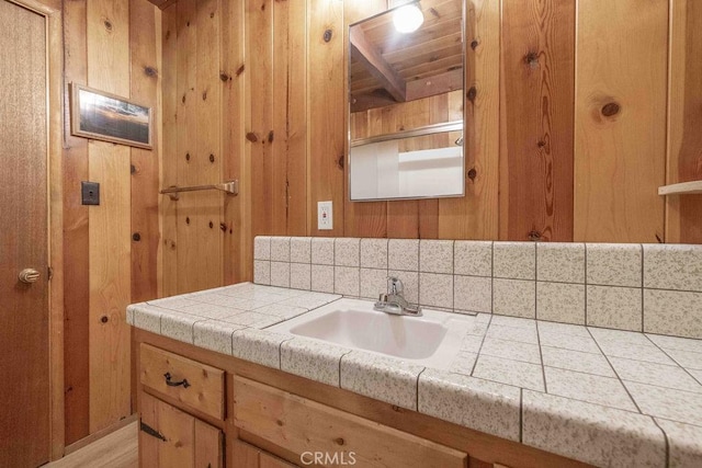 bathroom featuring vanity and wooden walls