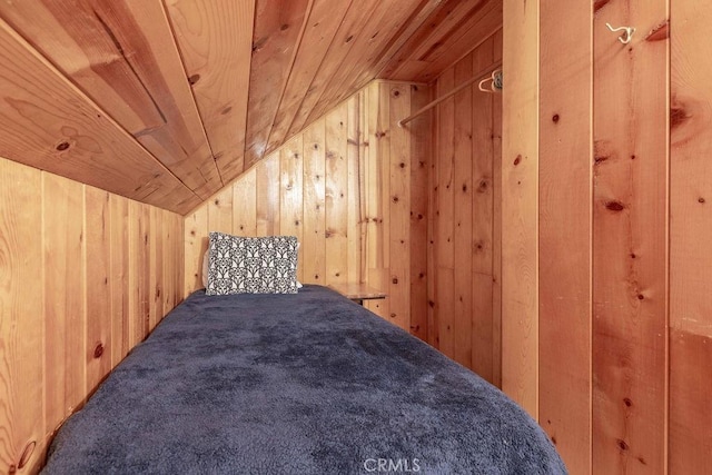 interior space featuring vaulted ceiling, wood ceiling, wood walls, and carpet floors