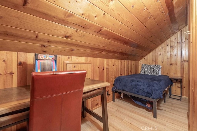 bedroom featuring light wood-style floors, wood ceiling, wooden walls, and vaulted ceiling