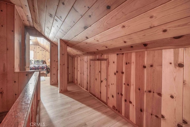 bonus room with light wood-type flooring, wooden ceiling, wooden walls, and vaulted ceiling