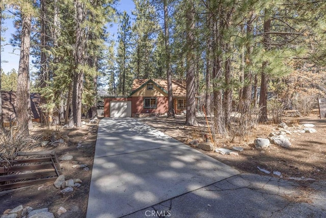 chalet / cabin featuring driveway and an attached garage