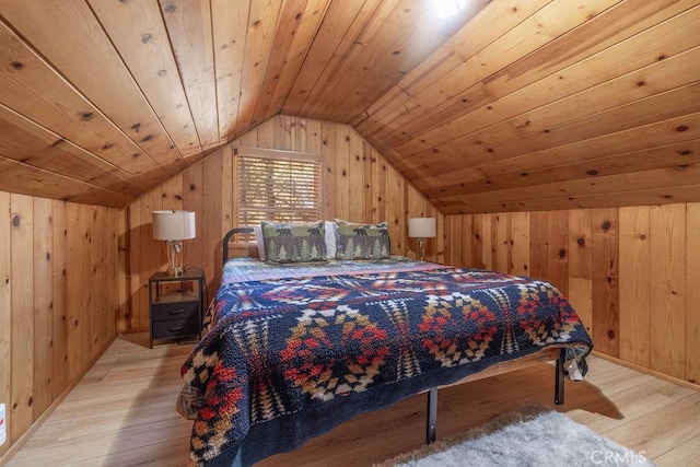 bedroom with vaulted ceiling, wood walls, wood ceiling, and light wood-style floors