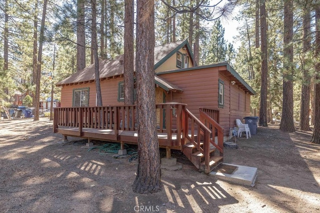 rear view of property featuring a wooden deck