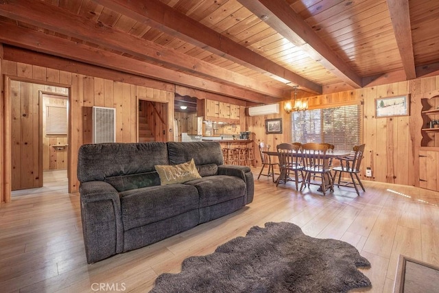 living area featuring beam ceiling, wood walls, a wall mounted air conditioner, and light wood-style flooring