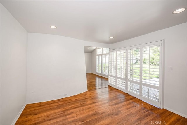 empty room with wood finished floors and recessed lighting