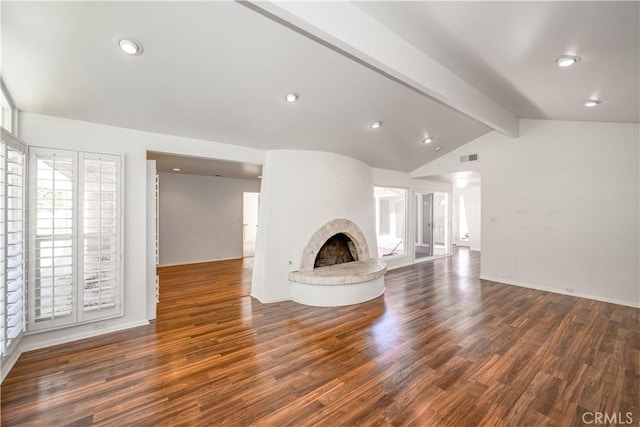 unfurnished living room featuring vaulted ceiling with beams, a fireplace with raised hearth, wood finished floors, and recessed lighting