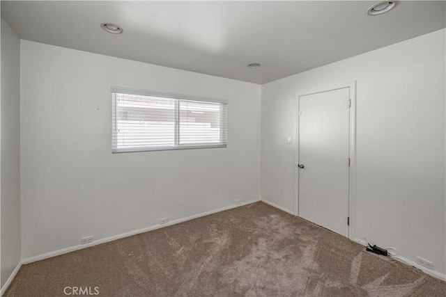 carpeted empty room featuring recessed lighting and baseboards