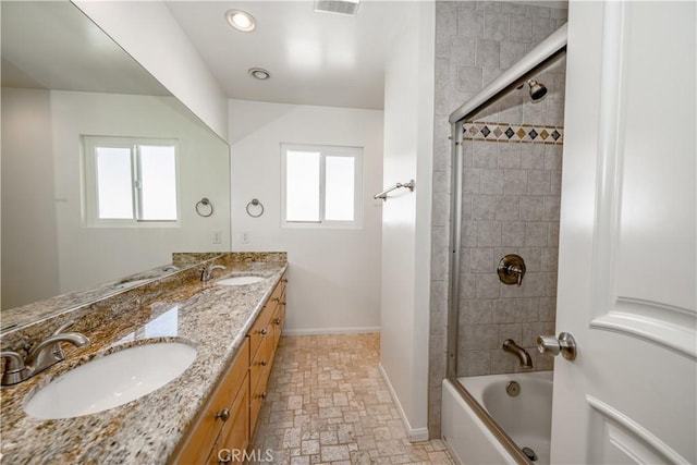 bathroom featuring double vanity, a sink, bathing tub / shower combination, and baseboards