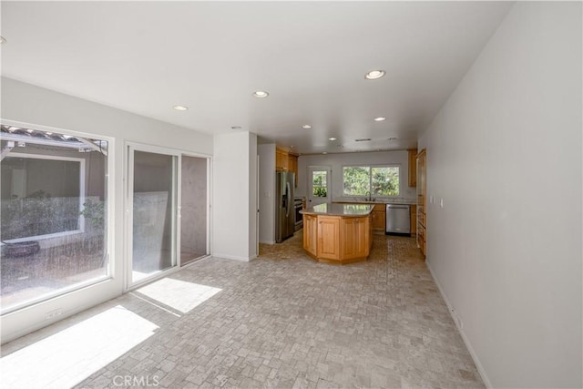 kitchen with baseboards, stainless steel appliances, a center island, and recessed lighting