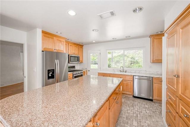 kitchen featuring recessed lighting, a sink, visible vents, appliances with stainless steel finishes, and a center island