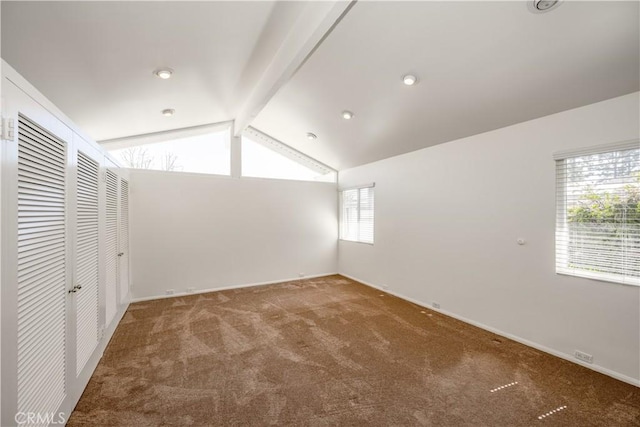 carpeted empty room with vaulted ceiling with beams