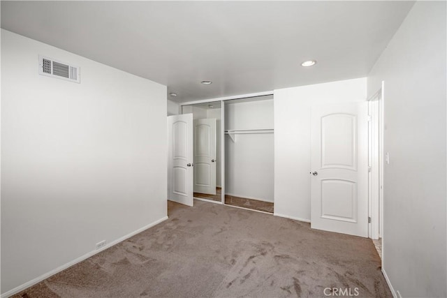 unfurnished bedroom featuring a closet, carpet flooring, visible vents, and baseboards